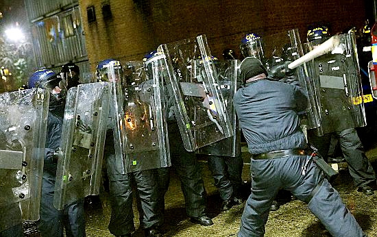 Police face a club-wielding “rioter” during the public order training session Police face a club-wielding “rioter” during the public order training session