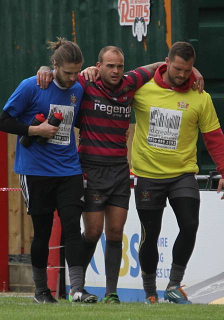 HELPED OFF . . . Oldham half-back Steve Roper exits the field