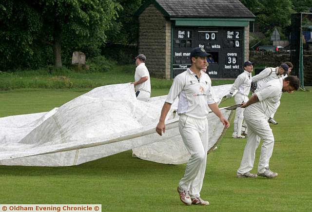 Greenfield v Rochdale, cricket match at Greenfield, Heavy rain dogged the start and play of the match. Players pull over the rain covers. Greenfield v Rochdale, cricket match at Greenfield, Heavy rain dogged the start and play of the match. Players pull over the rain covers.
