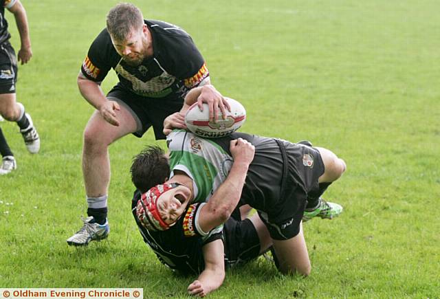 Harry Aaronson, of Saddleworth Rangers, feels the force of a Stanningley tackle. Harry Aaronson, of Saddleworth Rangers, feels the force of a Stanningley tackle.