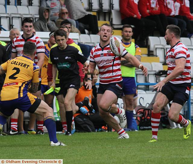 ON YOU GO . . . Danny Grimshaw (right) flicks a pass out to Adam Clay (centre) during Oldham's win.