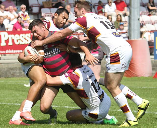 OUTNUMBERED . . . Oldham's Liam Thompson is held short of the home side's line. 