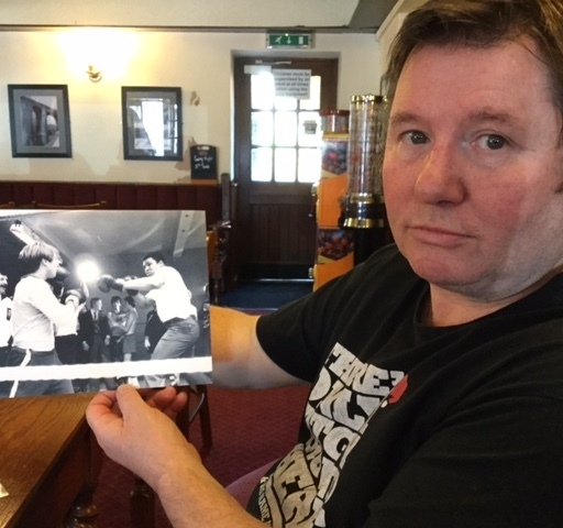 LES Close and the photo of him taking a surprise swing at iconic Muhammad Ali. LES Close and the photo of him taking a surprise swing at iconic Muhammad Ali.