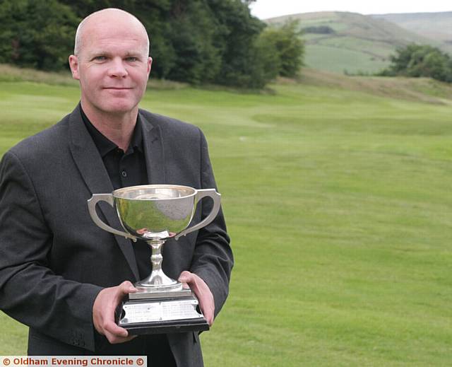 HAT-TRICK . . . Kris Sutcliffe shows off the Oldham and District Championship trophy