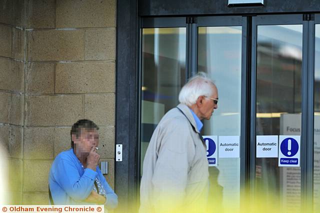 A PATIENT runs a gauntlet of smoke outside a local surgery