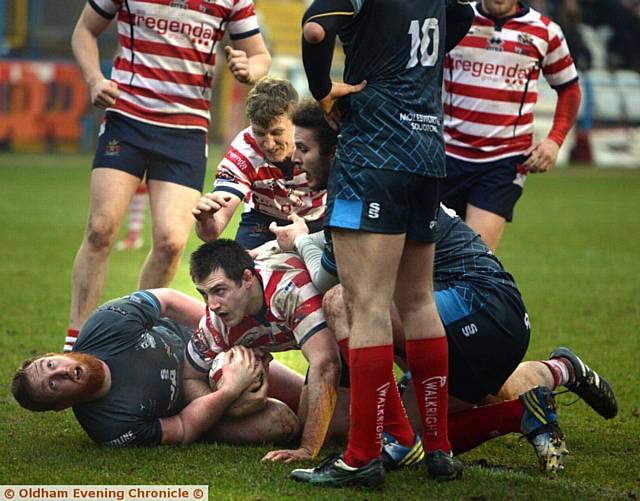 CRASHING HOME . . . Phil Joy of Oldham (centre) gets over the line. 
