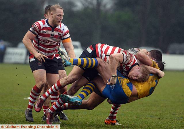 HEADING FOR A FALL: Oldham's George Tyson forces a Swinton Lions rival to the floor in yesterday's warm-up game at Sale. 