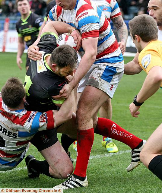 Oldham Rougheds V Rochdale Hornets, match played at the Spotland ground, Rochdale. Oldham player,(green strip), Jorden Walne, is held up from scoring a try by the Rochdale players.