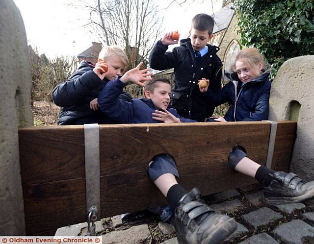 Pupils from Thorp Primary School visit the stocks outside St. Paul's Church, Royton, which have been restored by Royton Local History Society. Pic shows Oscar Bailey being bombarded by his classmates left to right, Roan Mallinson, Blake Beckman, Aimee Leigh.