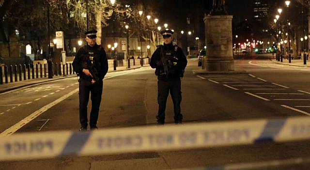 STANDING guard . . . two officers at a cordoned off area on the way to the Houses of Parliament in central London