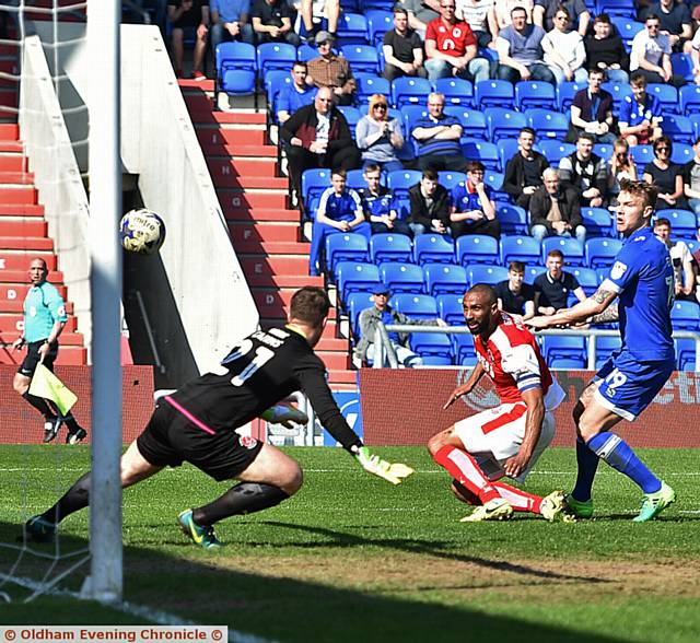 AHEAD IN THE GAME . . . Lee Erwin's effort is diverted into the net by Nathan Pond. 
