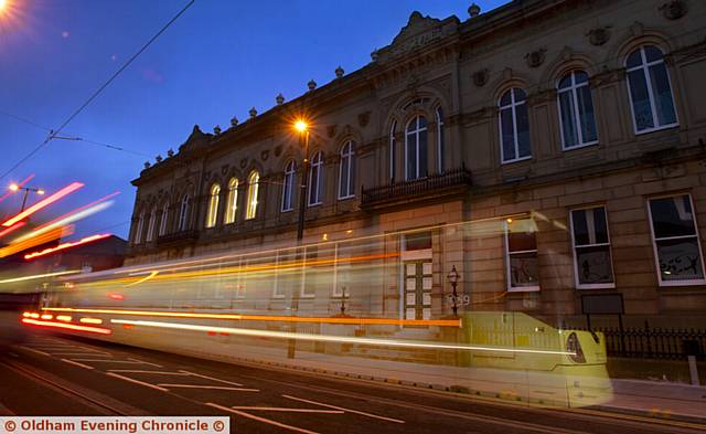 A Metrolink tram running past Oldham Lyceum