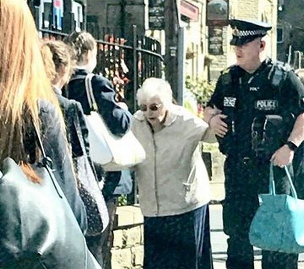 VILLAGE bobby Lee Cullen helps an elderly villager in Uppermill