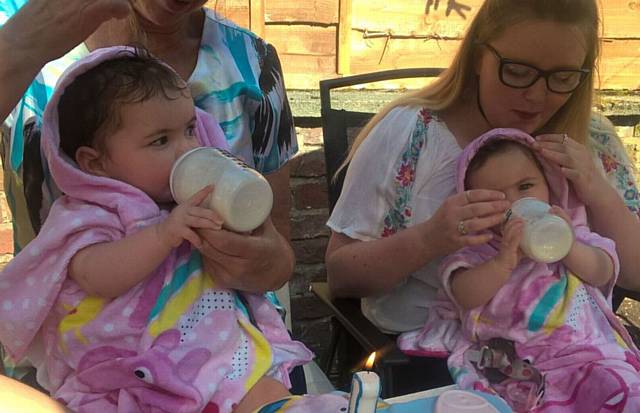 GOTTA lotta bottle . . . twins Lilly (left) and Millie with mum Lauren GOTTA lotta bottle . . . twins Lilly (left) and Millie with mum Lauren