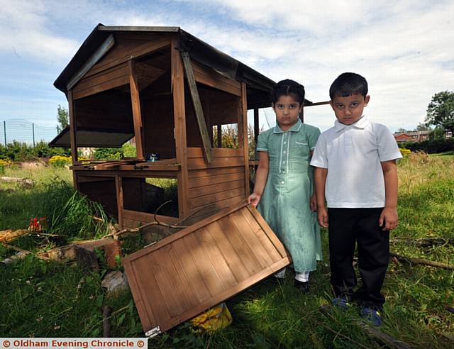 UPSET . . . pupils Noor Al-Haya (left) and Mohammed Ayaan with the vandalised chicken coop