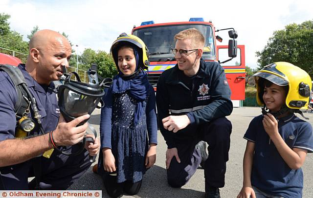 FirefighterS Arif Ahmed, left, and Ben Dewhirst with Halima Mahmood (11), Umar Mahmood (8).