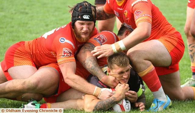 SQUEEZING HOME . . . Kenny Hughes bags Oldham's third try