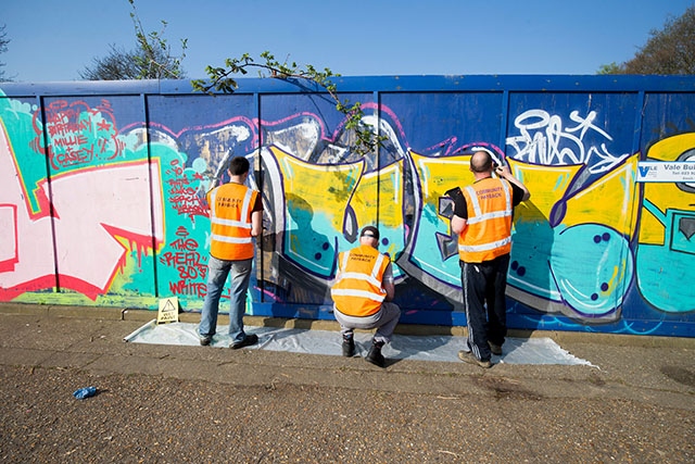 Doing their bit: Offenders clearing graffiti from a wall