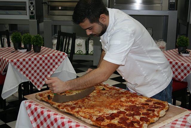 Have a go at the charity Pizza Challenge at Linda Lewis Kitchens' Oldham base. Pictured is chef Fabio Aurelio.