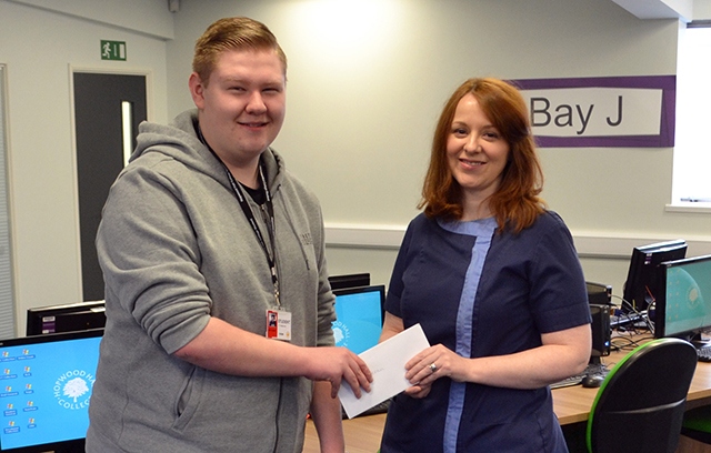 Rochdale Ear Clinic owner, Kath Scully, presents Kieran Cullinan with a gift reward for his website design