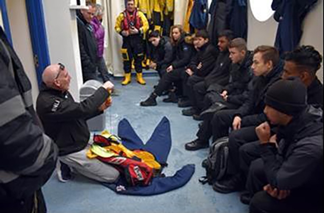 Students are shown how to deal with a potential drowning situation by a member of the RNLI Lifeboat team