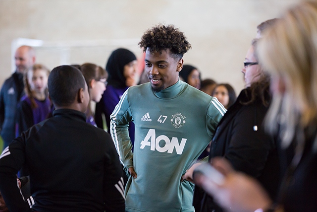 Manchester United prospect Angel Gomes meets some of the pupils at the Aon Training Complex