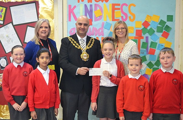 The Mayor of Oldham, Councillor Shadab Qumer, visited Knowsley Primary School to collect a cheque for £100  Children pictured are (left to right): Alicia Harrop, Sumayyah Alyas, Maisie Comer (Chair of the School Council - presenting the cheque), Joseph Baines and Finley Hampshire. The adults are (left to right): Miss Vanessa Payne (Headteacher) and Mrs Asia Anderson (Charities Co-ordinator and Year 4 teacher).