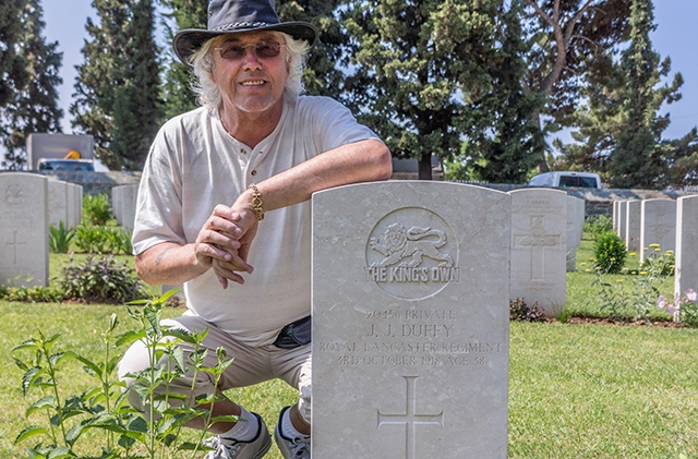 Michael Duffy at the grave of his grandfather, Oldhamer John James Duffy, in Greece