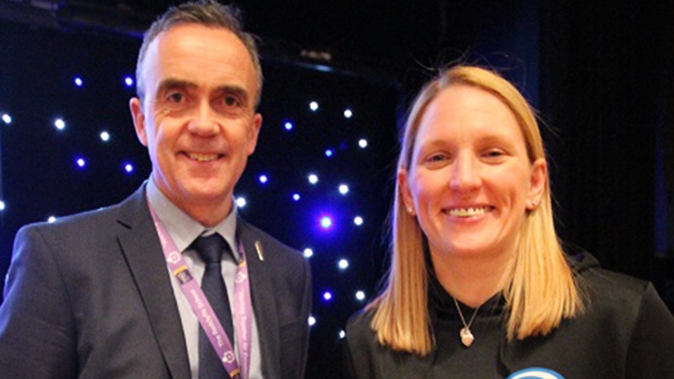 Stacey with Headteacher John Cregg and the boxing belts Stacey has won.