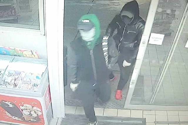 The two men are wanted in connection with the robbery at a petrol station in Oldham The two men are wanted in connection with the robbery at a petrol station in Oldham