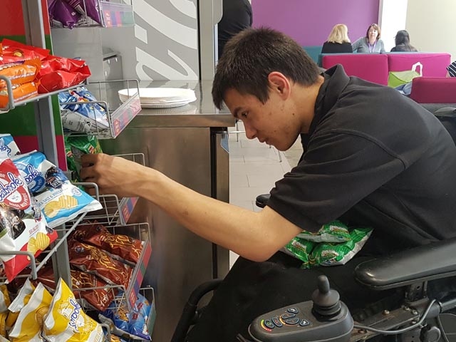 Edward from New Bridge School stocking shelves at FCHO atrium cafe
