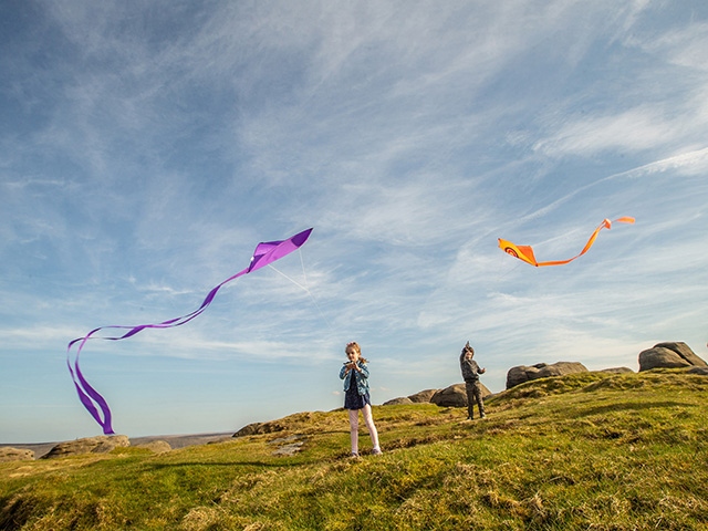 Children fly kites on a sunny day in the South Pennines. Pic courtesy of Craig Shaw. Children fly kites on a sunny day in the South Pennines. Pic courtesy of Craig Shaw.