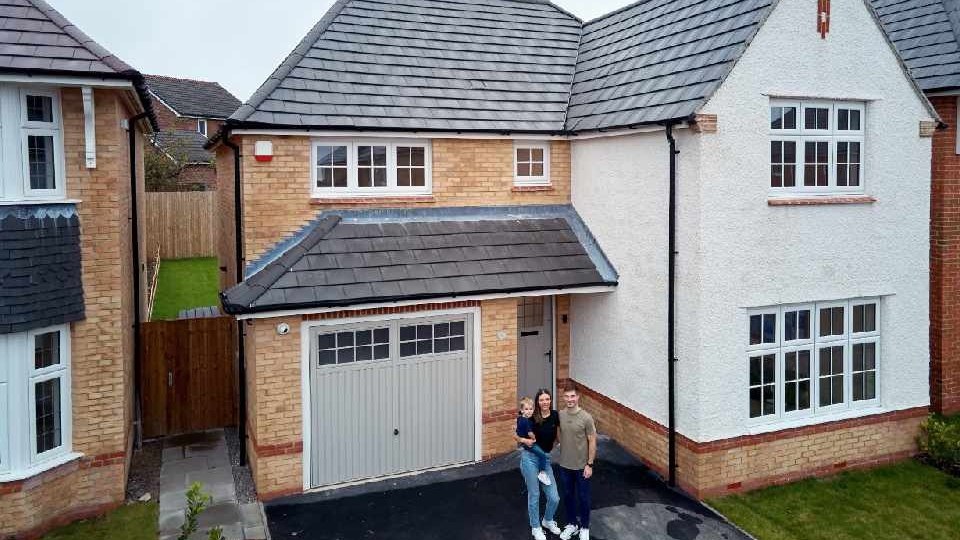 Megan Jones and Phil McGrath with son Harley outside their new home at Saddleworth View