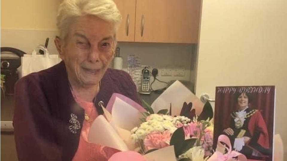 Mrs Smith is pictured with the mayor's birthday card and flowers