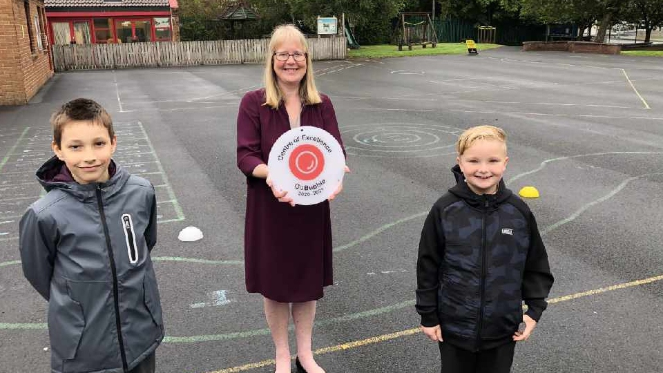 Mrs Milligan proudly shows off St Herberts' award