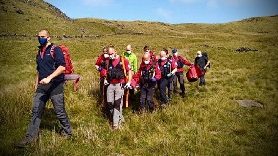 Members of Oldham Mountain Rescue team carrying the woman off Pots and Pans. Members of Oldham Mountain Rescue team carrying the woman off Pots and Pans.