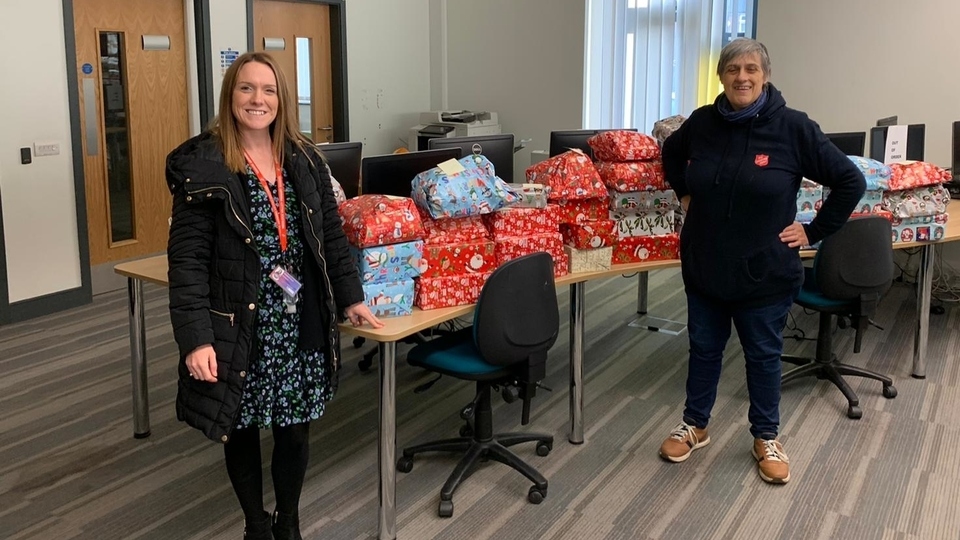 Salvation Army corps officer Major Estelle Blake (right) receives a present donation from Medlock Valley School. Image courtesy of the Salvation Army and Reel CIC