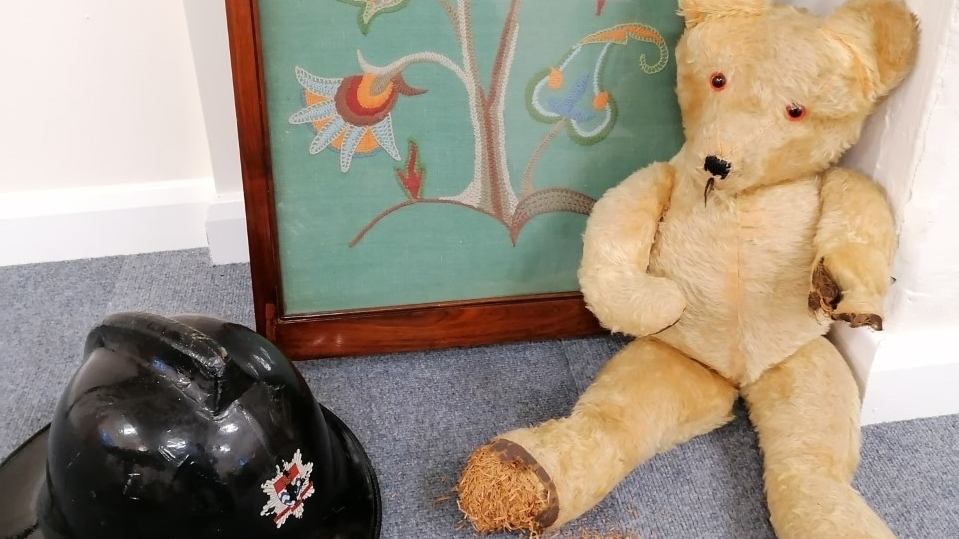 Some of the items donated, including a 1950s teddy, an original London fire brigade helmet and an embroidered picture Some of the items donated, including a 1950s teddy, an original London fire brigade helmet and an embroidered picture