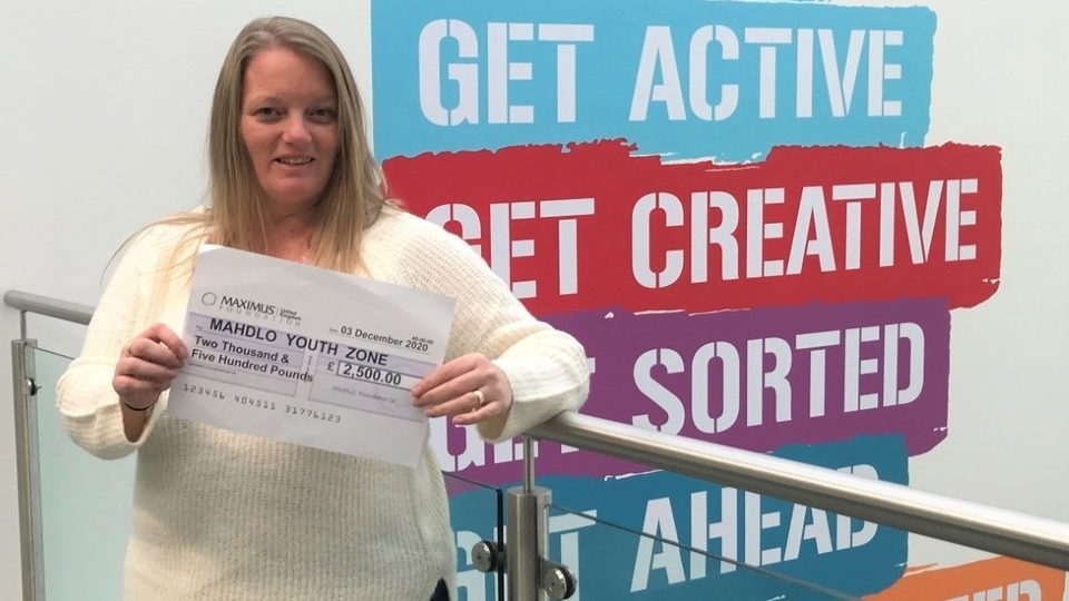 Claire Crossfield, Fundraising Manager at Mahdlo, shows off the cheque