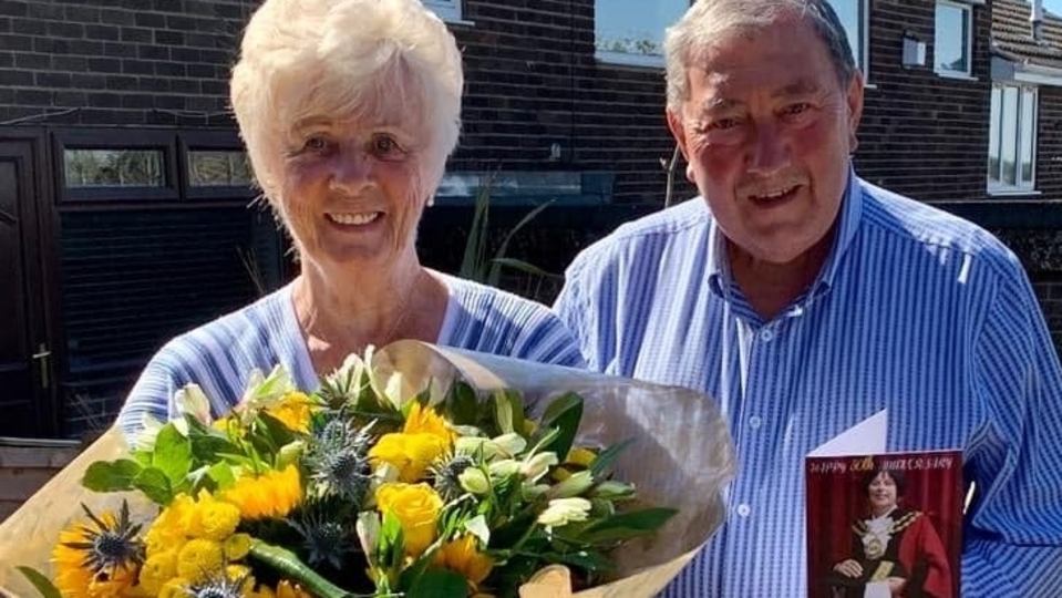 Heather and Barry Dunkerley with their flowers and card from the Mayor of Oldham, Councillor Ginny Alexander