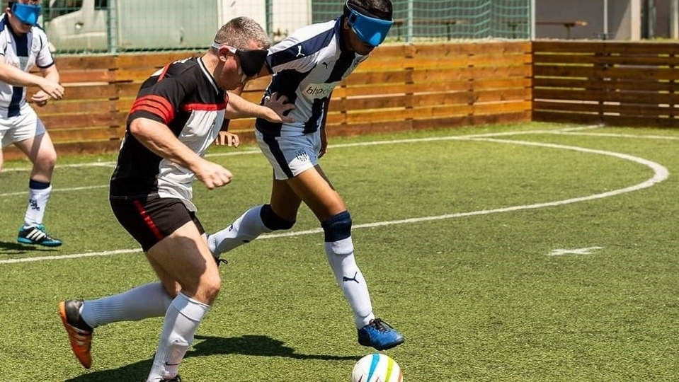 Participants in action playing blind football and goalball