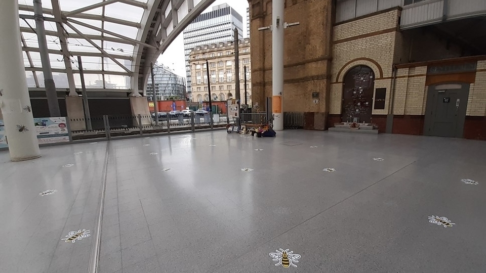 Floor stickers in the shape of the Manchester worker bee have been placed on the floor at Victoria station