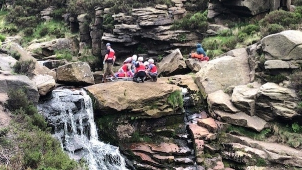 The rescue team tend to the casualty close to the waterfall in Birchen Clough
