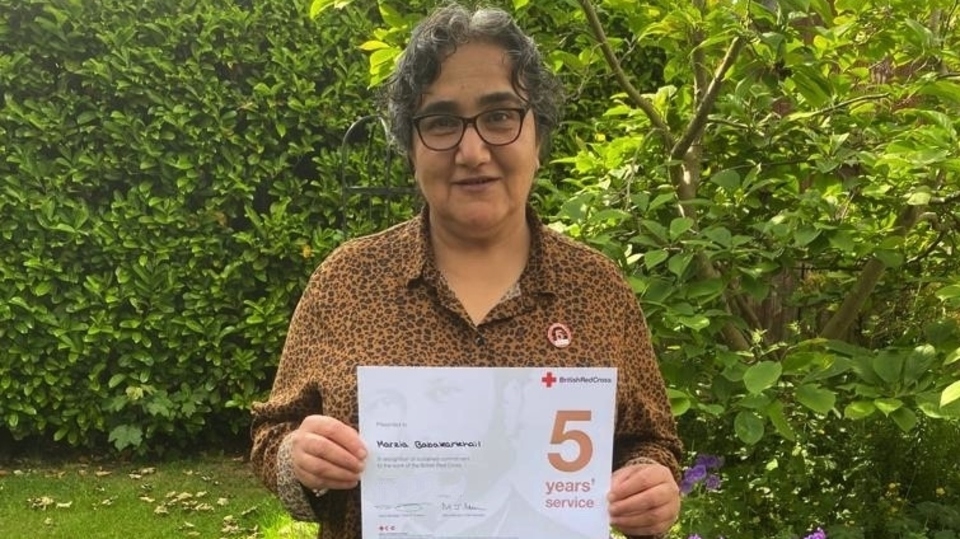 Marzia proudly holding her British Red Cross five years service certificate