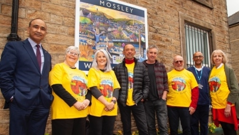 Pictured are members of the Mossley Town Team with artist Chris Cyprus and Dr Duper of the Pennine Medical Practice. Left to right are: Idu Miah, Chris Lyness, Pauline Coates, Mark Braks Speare, Chris Cyprus, Paul Dowthwaite, Dr Duper and Mary Booth