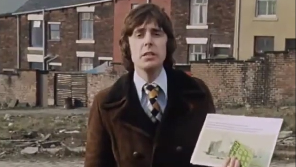 John Stapleton with a 'glossy brochure'