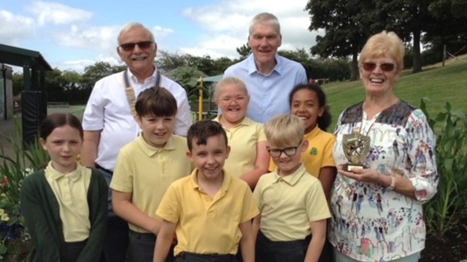 Pupils and Mr Deville receiving the trophy from Mrs Gaynor Mellor watched by Rotary Club President Garvin Crabtree. Pupils and Mr Deville receiving the trophy from Mrs Gaynor Mellor watched by Rotary Club President Garvin Crabtree.