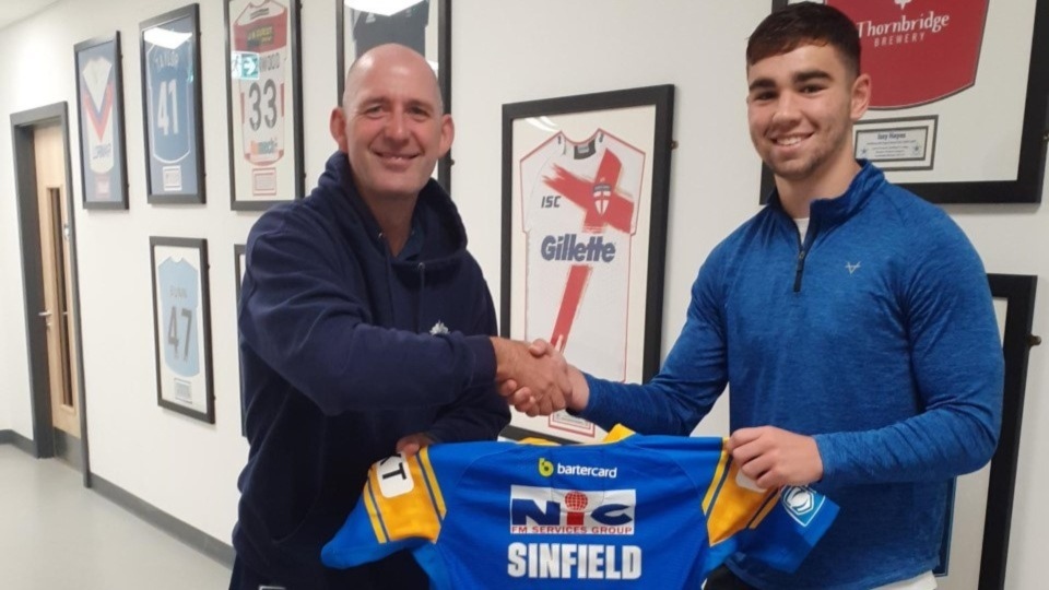 Jack Sinfield presents his team shirt to PE teacher Gary Melling