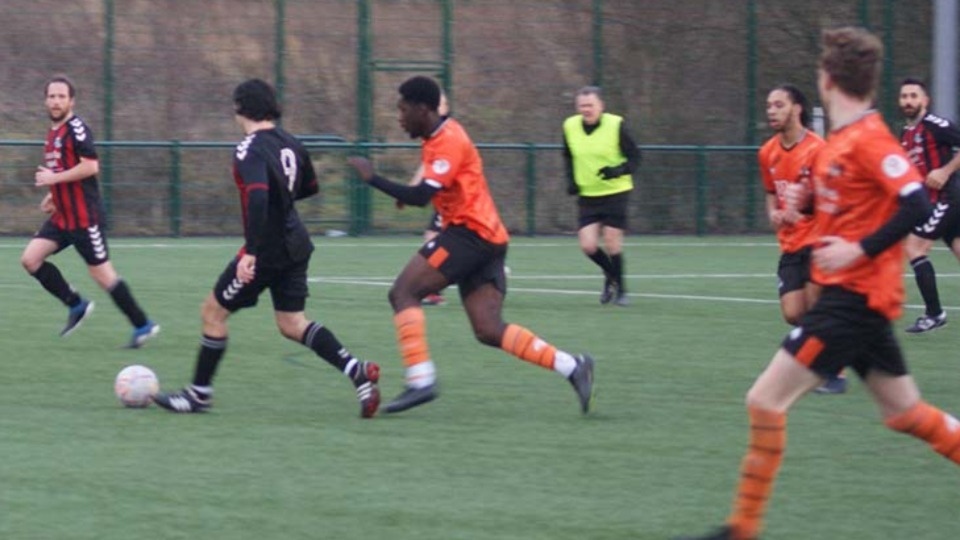 Action from the Division Two clash between Trafford United and AFC Oldham (orange shirts)
