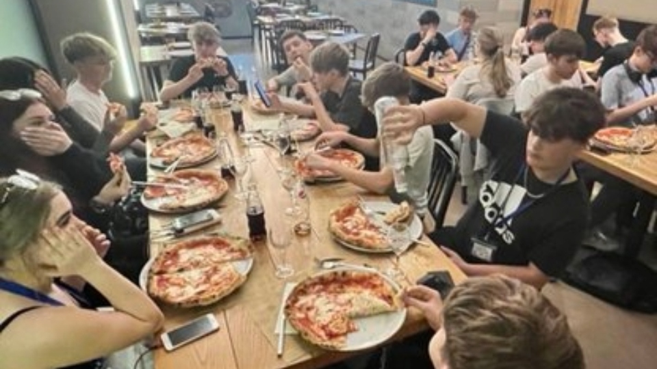 Students tuck into their pizzas in Italy